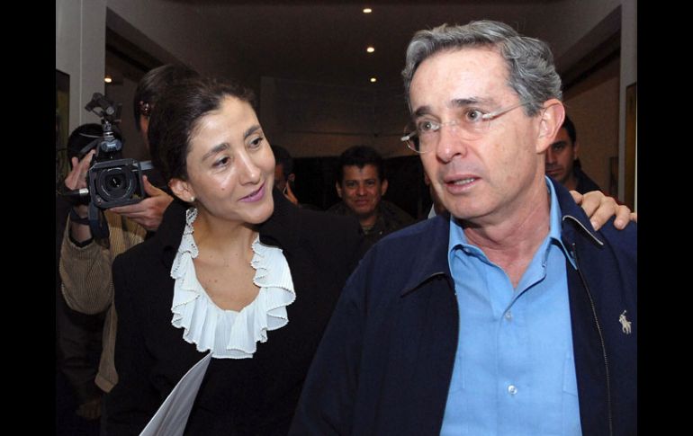 • Íngrid Betancourt tiende el brazo al presidente de Colombia, Álvaro Uribe, en Bogotá. AFP  /
