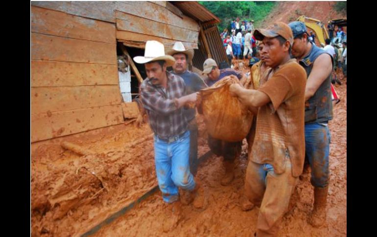 Varias personas tratan de rescatar cuerpos atrapados en un derrumbe en el municipio indígena de Amatán. EFE  /