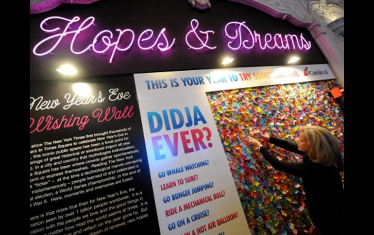 na mujer fija una pieza de confeti en el muro de deseos en el Centro de Información de Times Square. NTX  /