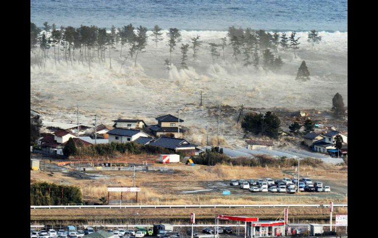 Una serie de olas se interna en tierra firme en Natori, Estado de Miyagi. REUTERS  /