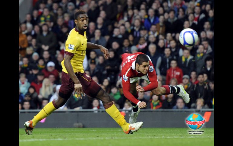 El arquero del Arsenal, Manuel Almunia (izq.), detiene un  cabezazo del “Chicharito”, que originó el primer gol del 'ManU'. REUTERS  /