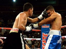 El mexicano Cristian Mijares (izq.) intercambia puños con Carlos Rueda durante una pelea por el campeonato supermosca de la FIB. EFE  /