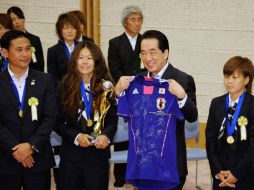 El primer ministro, Naoto Kan (2d), sostiene una camiseta firmada  junto a las jugadoras Homare Sawa (2i) y Aya Miyama (d). EFE  /