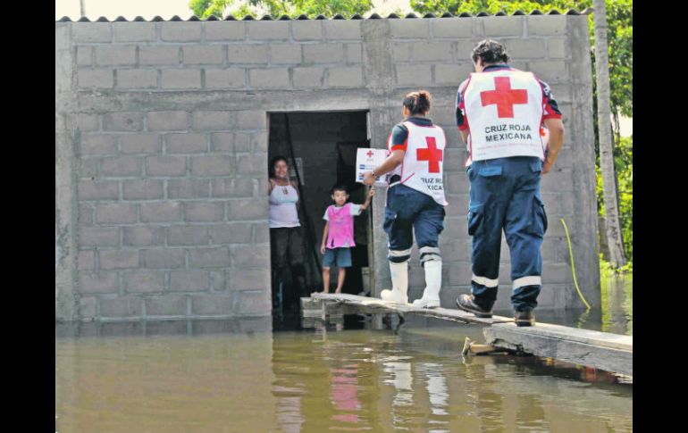 Socorristas de la Cruz Roja arriban a una vivienda con un par de despensas.  /