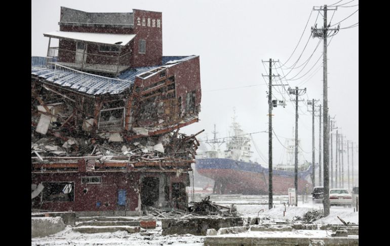 Los restos de un edificio (i) y de un barco (c) que quedaron destruidos en el tsunami de hace un año. el 11 de marzo de 2011. EFE  /