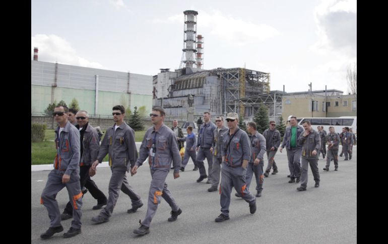 Trabajadores de la construcción que montarán el sarcófago caminan por la inmediaciones de Chernobyl.  AP  /
