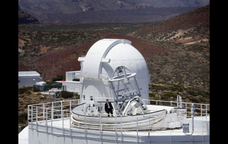 Un hombre posa junto al telescopio Gregor, en Tenerife. Se aprecia plegado el techo retráctil, que permite una mejor refrigeración. AFP  /