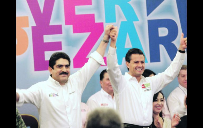 Manuel Espino (izquierda), levanta la mano del candidato priista, Enrique Peña Nieto, tras declararle su apoyo. EL UNIVERSAL  /