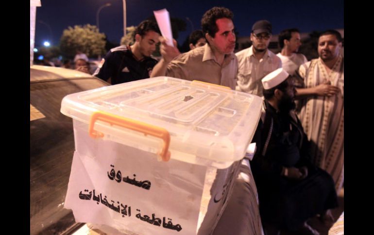 Manifestantes antielecciones rodean una urna en la que se lee en árabe 'caja de boicot a las elecciones'. EFE  /
