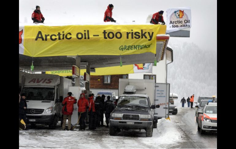 Fotografía que muestra a los activistas encadenados a  la gasolinera de Shell. EFE /