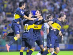Guillermo Burdisso (centro), quien festeja con sus compañeros, fue la figura del Boca al anotar dos goles en la recta final del partido AP /