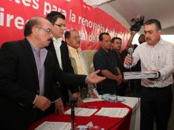 Contreras Zepeda (d) entrega su documentación ante integrantes de la Comisión Estatal de Procesos Internos del PRI Jalisco. ESPECIAL /