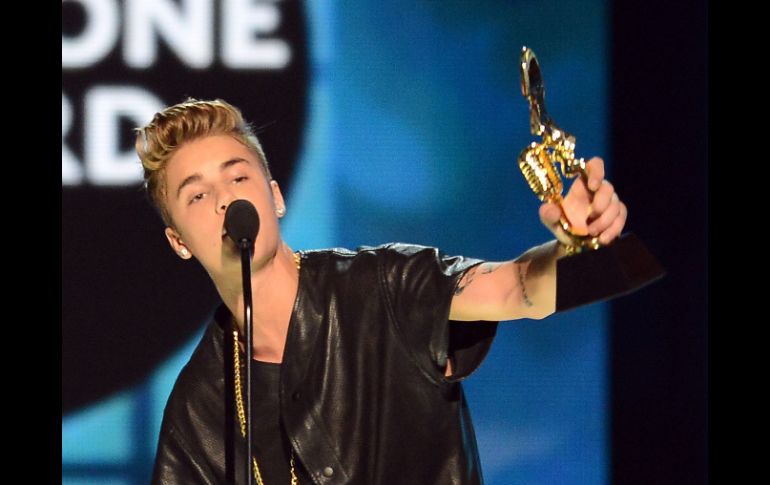 Justin Bieber muestra el premio recibido en la ceremonia de los Billboards. AFP /