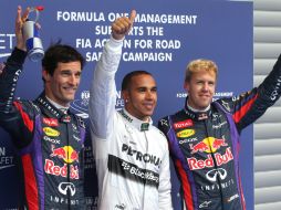 Lewis Hamilton (c) y Sebastian Vettel (d), calificado en el segundo puesto, junto a Mark Webber (i) al terminar la ronda. AFP /