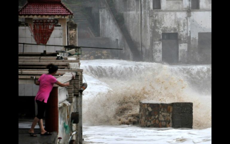 Aquí, una mujer ve como el agua corre por las calles de su ciudad. AFP /