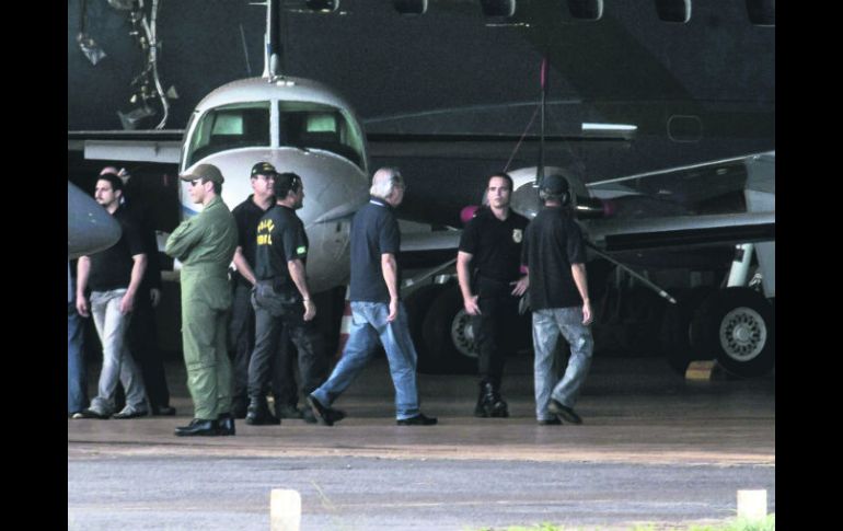 José Dirceu (tercero a la derecha), implicado en el escándado ''mensalão'', a su llegada al hangar de la Policía Federal en Brasilia. AFP /