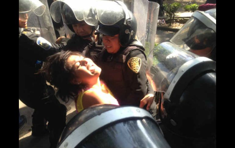 Una joven al momento de ser detenida por granaderos, afuera de Televisa. SUN /