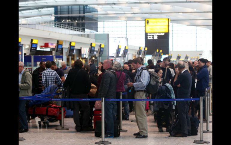 Pasajeros hacen fila para volver a reservar vuelos en el Heathrow Airport de Londres. AP /