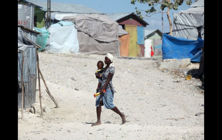 Una mujer caminando con un bebé en brazos por el campamento de desplazados en Carradeux, Puerto Príncipe. EFE /