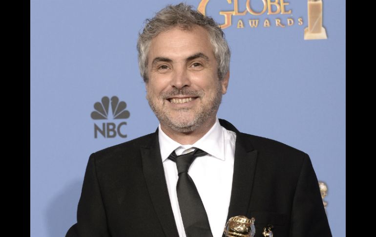 Alfonso Cuarón sostiene el premio al momento de lucir una gran sonrisa. AFP /