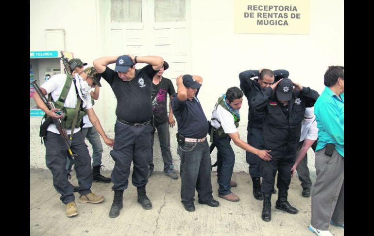PARADOJAS. Autodefensas encapuchados registran a policías de Nueva Italia, municipio de Múgica, Michoacán. AP /