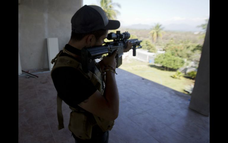 Un integrante de autodefensa se atrinchera en uno de los puntos de revisión de Nueva Italia, Michoacán. AP /