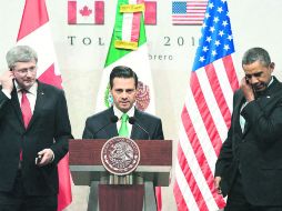 Barack  Obama y el premier Stephen Harper escuchan por los audífonos las palabras del Presidente Enrique Peña Nieto a empresarios. AP /