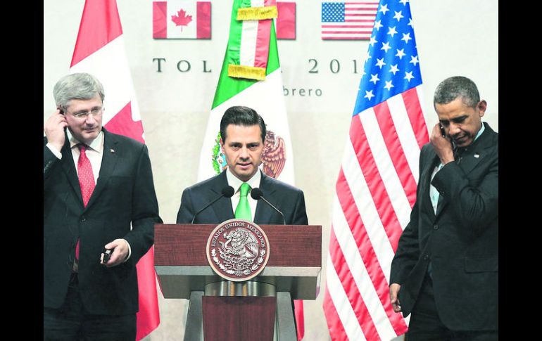 Barack  Obama y el premier Stephen Harper escuchan por los audífonos las palabras del Presidente Enrique Peña Nieto a empresarios. AP /