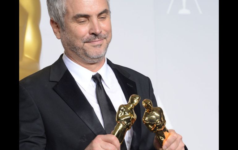 El director mexicano, Alfonso Cuarón, con los dos galardones obtenidos durante los Oscar de este año. AFP /