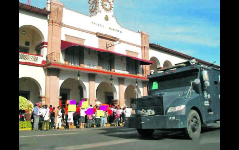 Sale. Policías federales apoyaron al edil Uriel Chávez para que saliera de la alcaldía. Afuera había protestas en contra y a favor. EFE /