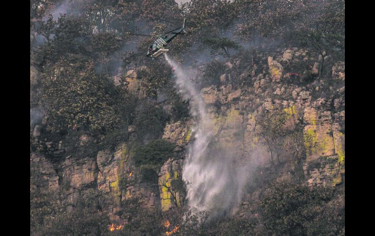 Descarga. Un helicóptero rocía una zona del Cerro del Tepopote.  /