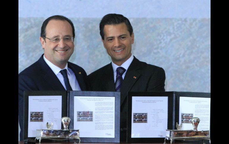 El presidente de Francia, François Hollande (i), y su homólogo de México, Enrique Peña Nieto (d), muestran la cancelación de un timbre. EFE /