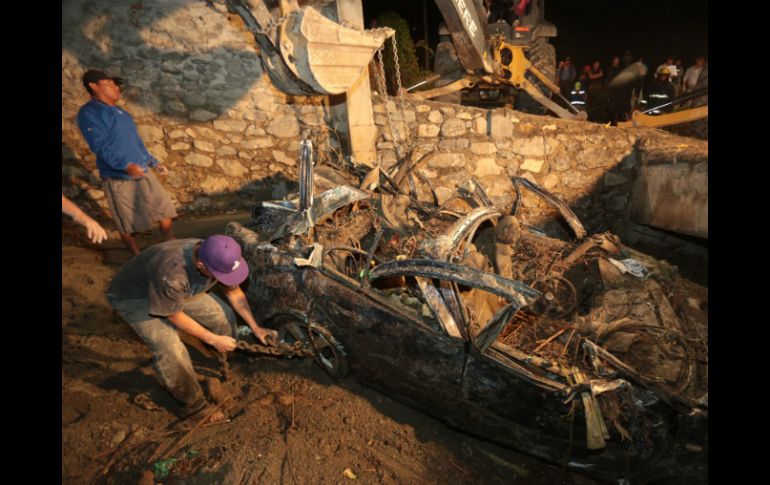 Una tromba provocó un deslave que dejó automóviles sepultados en Huehuetlán el Grande. AFP /
