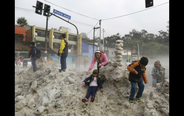 Niños juegan en una pila de hielo en las calles de Sao Paulo. AP /