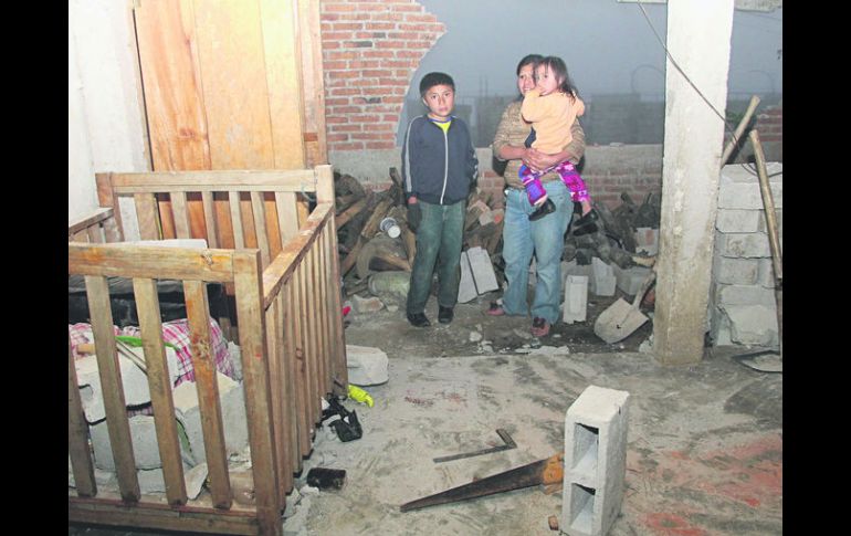 Daños. Una familia observa los destrozos que dejó el fenómeno en su vivienda, en Huixtla. AFP /