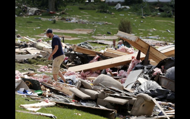 Residentes de Smithfield, el pueblo rural del centro de Nueva York, revisan los escombros de lo que queda de sus viviendas. AP /