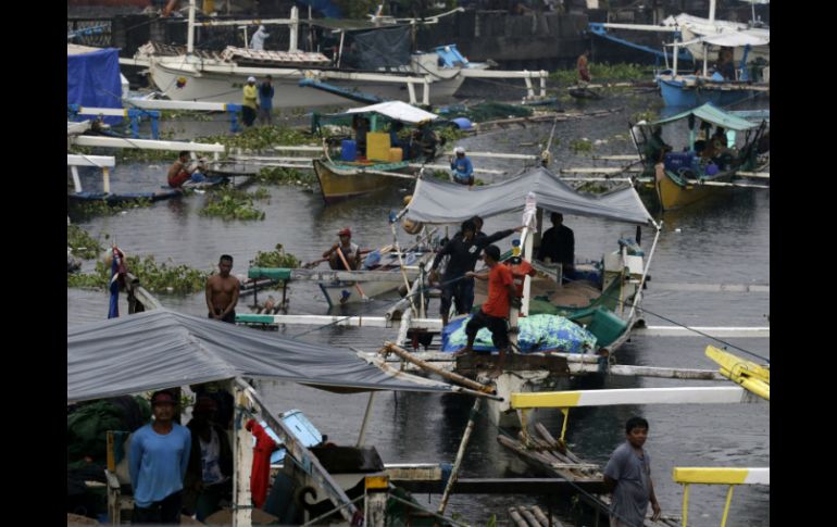 Pescadores filipinos se refugian de las fuertes olas provocadas por el próximo tifón. EFE /