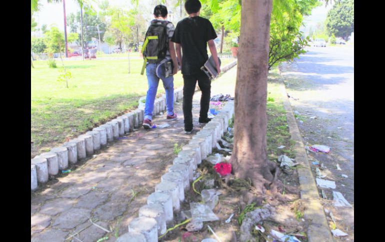 Un par de jóvenes contempla el abandono de la calle compartida por dos municipios.  /