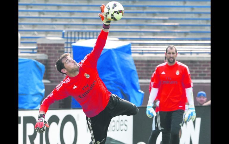 Casillas vuela para detener un disparo ayer durante el entrenamiento blanco, ante la mirada de Diego López. EFE /