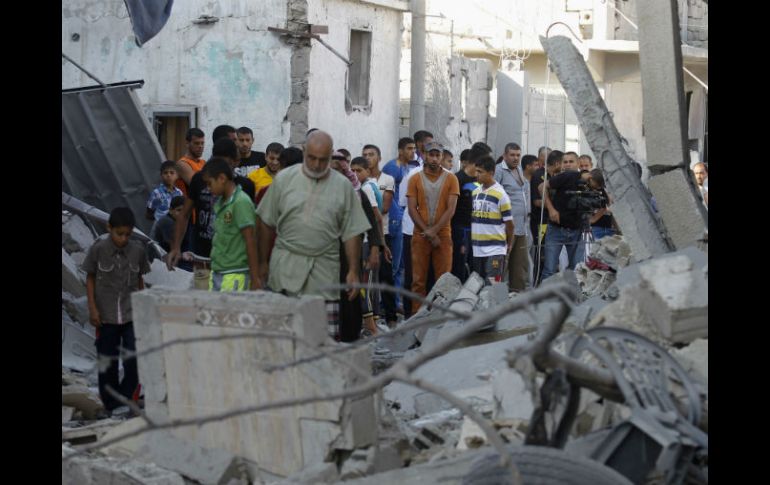 Ciudadanos de Rafah inspeccionan una casa después de que fue golpeada por un ataque militar. AFP /