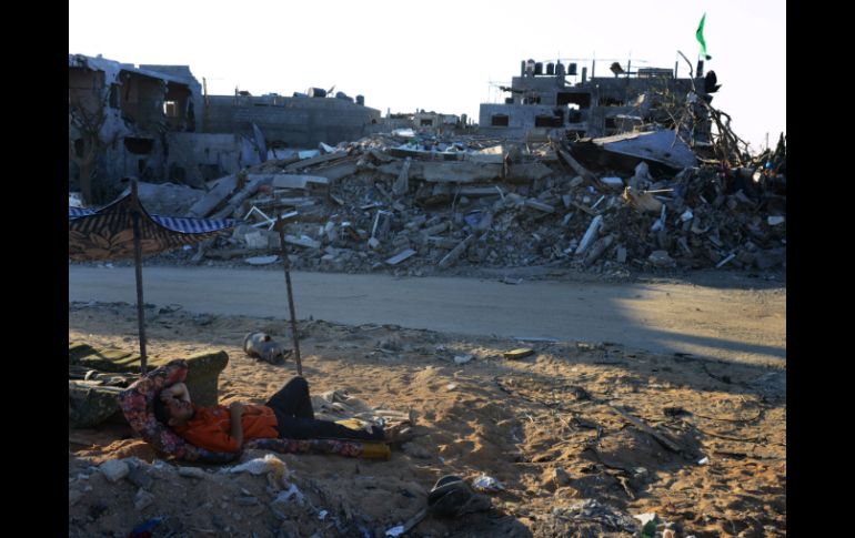 Un palestino descansa cerca de los restos de un edificio en Beit Hanun, al norte de Gaza. AFP /