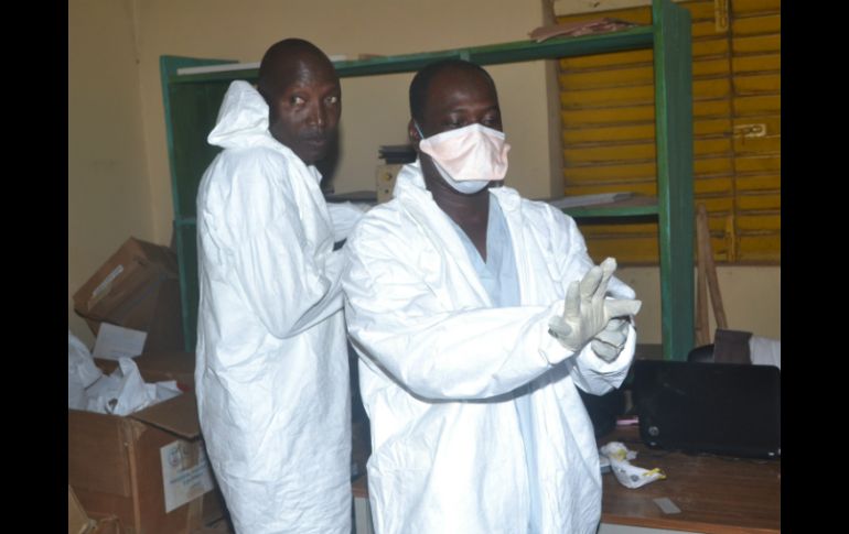 Enfermeros se retiran su traje de protección tras terminar su trabajo en un hospital de África. AFP /