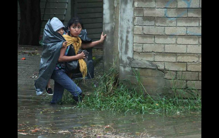 Una mujer cruza una calle inundada en Oaxaca. Se prevé que hoy 'Odile' se convierta en huracán. EFE  /