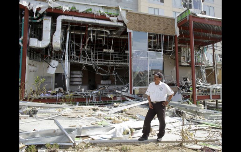 Un guardia de seguridad se para frente a un hotel destruido por el paso de 'Odile'. AP ARCHIVO /