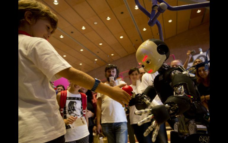 El androide iCub interactúa con un niño en la European Maker Faire, en Roma. AP / A. Tarantino