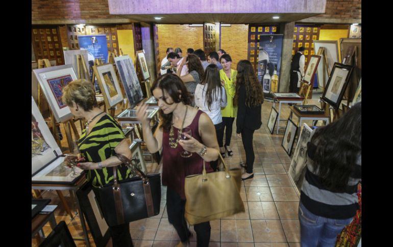Los asistentes disfrutan de canapés, tequila y vino mientras observan las obras en venta. EL INFORMADOR / F. Atilano