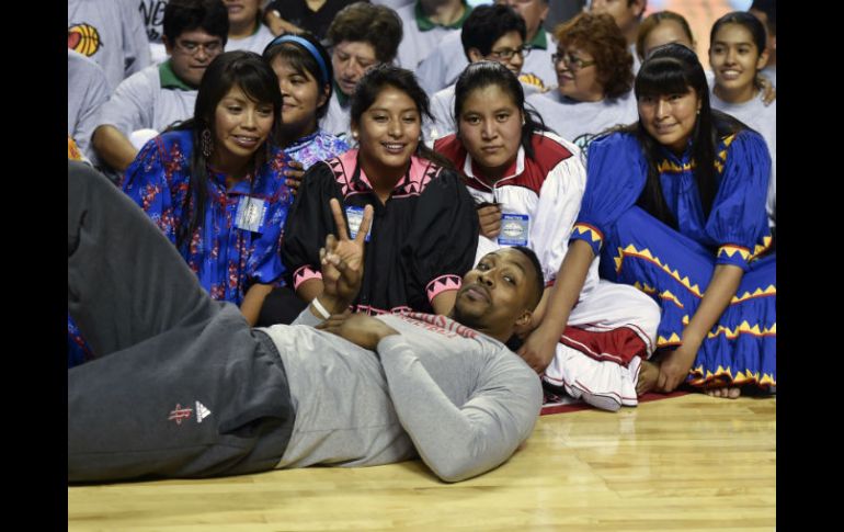 Dwight Howard, de los Rockets de Houston, posa con jóvenes tarahumaras invitadas al entrenamiento en la Arena Ciudad de México. AFP / Y. Cortez