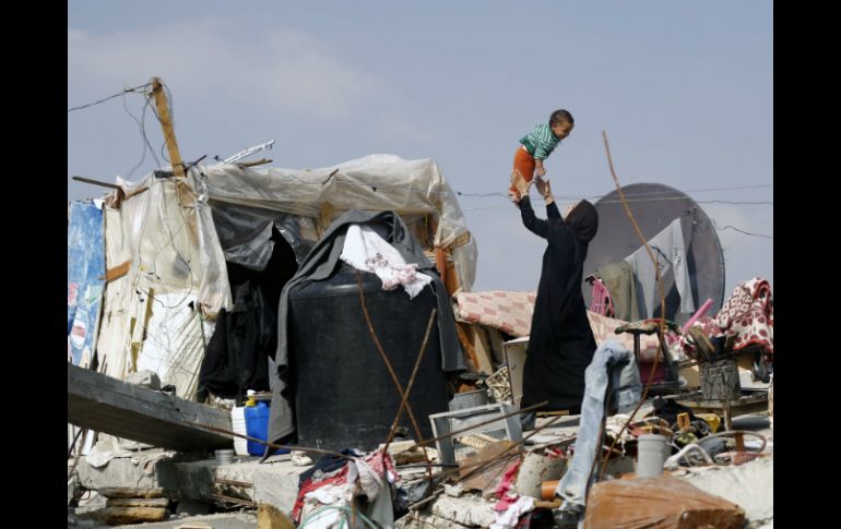 Una mujer palestina sobre los escombros de la casa de su familia que fue destruida durante la guerra de Gaza. AFP / M. Abed