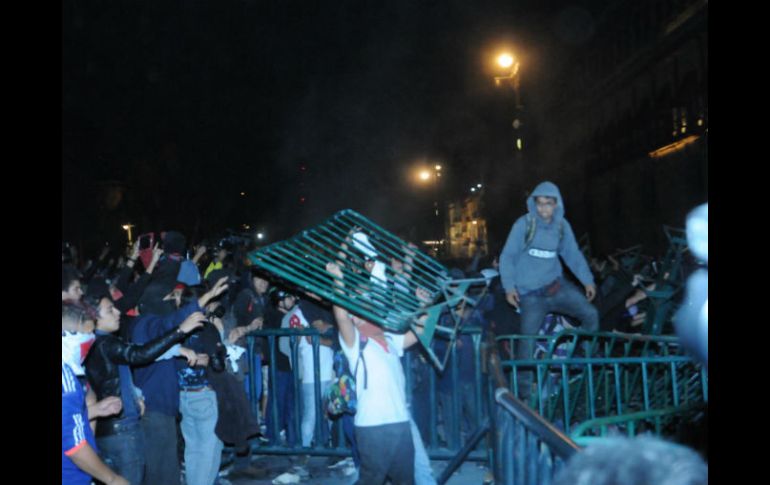 Antes de que llegaran los granaderos, un grupo de encapuchados trataba de quitar las barreras frente al Palacio Nacional. SUN / RCC