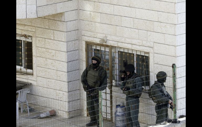 Policías israelíes resguardan la casa de los primos Ghassan y Oday Abu, responsables del ataque a una sinagoga el pasado noviembre 18. AP /  M. Illean